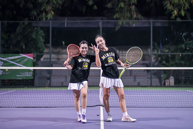 Doubles partners in matching shirts posing on court