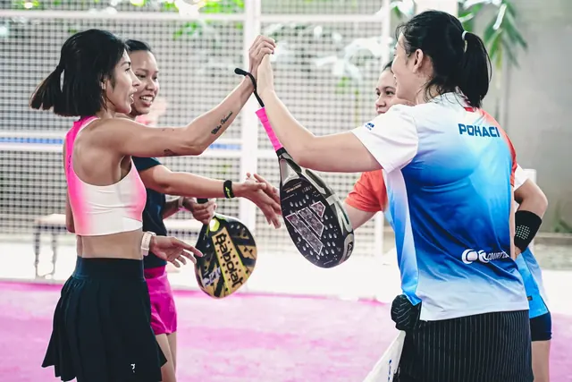 Padel players high-fiving across the net after a game